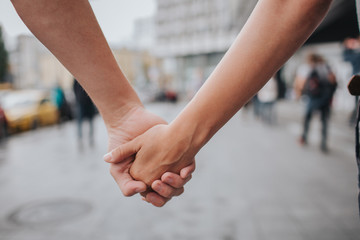 Couple hands closed together outdoors in love and romantic relationship. Close up body. man and woman in the city
