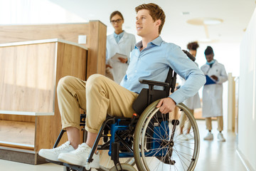 man in wheelchair at hospital corridor