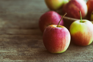 Stack of fuji apple and in basket put on wood table for background or wallpaper in vintage tone style. Delicious sweet and juicy fuji apple for salad cooking or bakery.Fuji apple has origins in Japan.