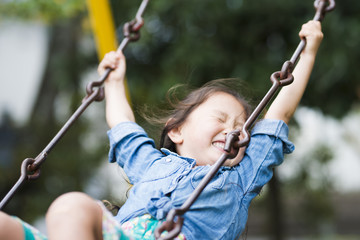 Little girl playing with a swing