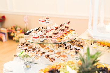 Delicious sweets on wedding candy buffet with desserts, cupcakes