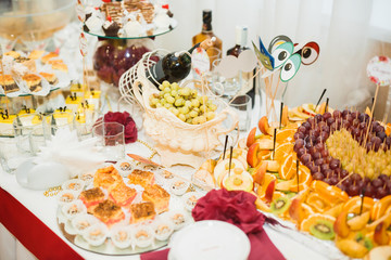 Delicious sweets on wedding candy buffet with desserts, cupcakes