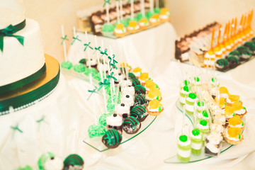 Delicious sweets on wedding candy buffet with desserts, cupcakes