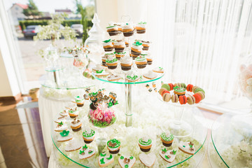 Delicious sweets on wedding candy buffet with desserts, cupcakes