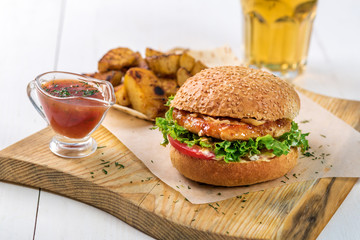 Fast food dish. Appetizing meat burger, potato chips and sauce. Takeaway composition.