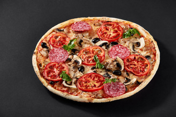 Food ingredients in pizza on black concrete background.