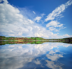 Beautiful lake river and spring green hills.