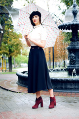 Young Parisian woman walking under the rain