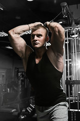 Strong man with tatoo working in gym 