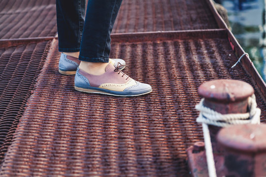 Female Feet In Shoes Standing On The Pier