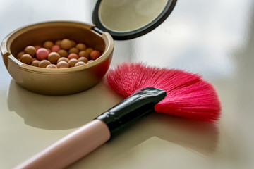 Close up of makeup, pearls and blush brush. Shallow depth of focus. Concept fashion and beauty.