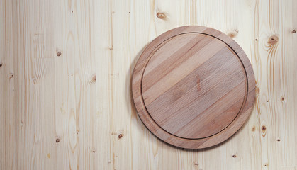 empty round wooden board for cutting on a wooden background