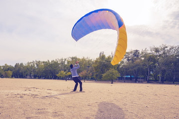 Man is practicing to control a paraglider