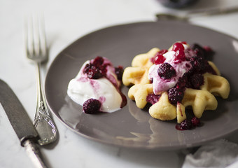 Waffle con yogurt e frutti di bosco su tavolo in marmo bianco. Prima colazione