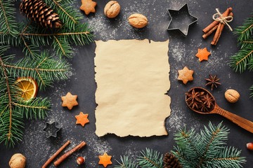 Obraz na płótnie Canvas Santa wishlist or Christmas letter background concept: holiday decorations, fir tree, spices, stars and cookie cutters with blank paper for text . Top view, horizontal