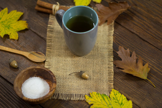Hot tea on rustic background in the autumn ambiance