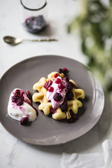 Waffle con yogurt e frutti di bosco su tavolo in marmo bianco. Prima colazione