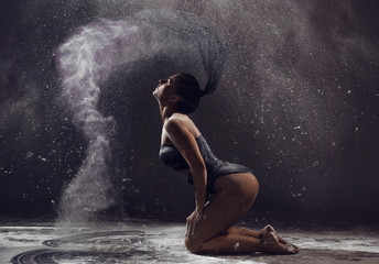 Art perfomance - dancer moving in cloud of dust