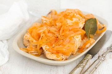 turkey with onion on dish on wooden background