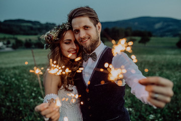 Beautiful bride and groom on a meadow in the evening.