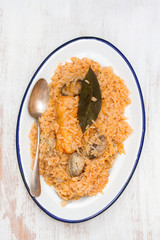 rice with seafood and fish on dish on wooden background