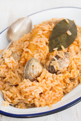 rice with seafood and fish on dish on wooden background