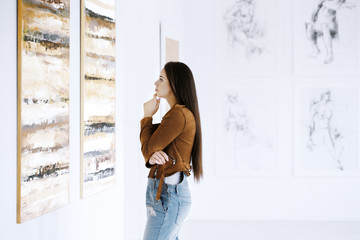 Young woman observing painting