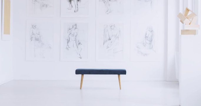 Time lap of thoughtful woman sitting on stool against wall with drawings gallery. Art gallery concept

