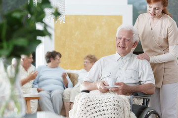 Elder holding cup of coffee