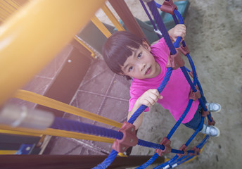 Fototapeta na wymiar Child looking up. Climbing rope in playground