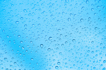 Rain on glass. Water drops on blue background.