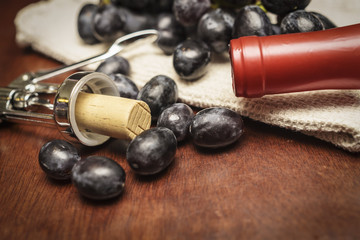 grapes with a wine bottle and cork screw