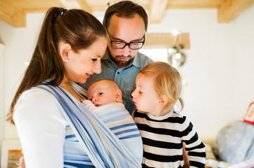 Obraz premium Young parents with two children at Christmas time.