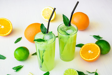 Transparent refreshing cocktail with cucumber, limes and orange
