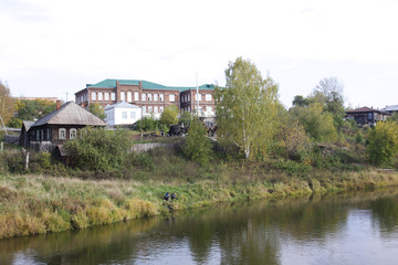 River, on the other side of which are houses in greenery