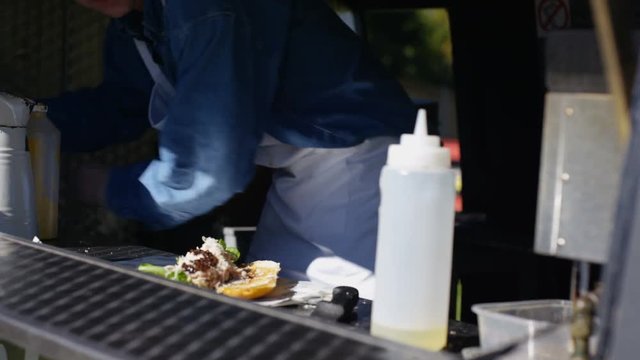  Street food vendor making hot meat snacks for customers at summer festival