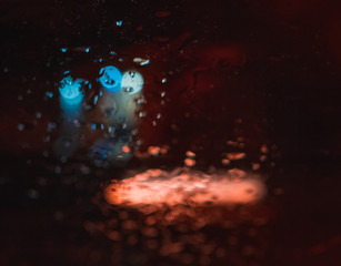 Magnificent city landscape in the side through the wet windshield of the car in the rain. Beautiful...