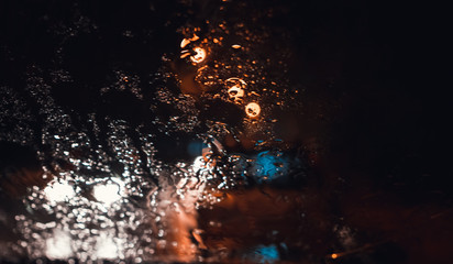 Magnificent city landscape in the side through the wet windshield of the car in the rain. Beautiful background