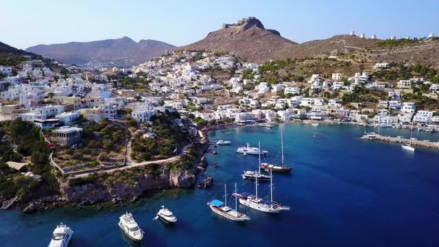 August 2017: Aerial drone video from picturesque village of Panteli with view to iconic fortified castle and windmills uphill, Leros island, Dodecanese, Greece