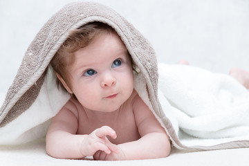 Cute baby after bath, parental care concept. Happy baby having fun. Three-months old baby looking up