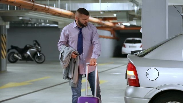 Businessman packs luggage to car's trunk and leaving
