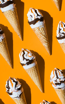 Caramel vanilla and chocolate ice creams on orange background.