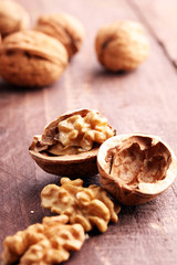 Obraz na płótnie Canvas Walnut kernels and whole walnuts on rustic old wooden table.