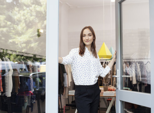 Portrait of store owner in door way of her boutique.