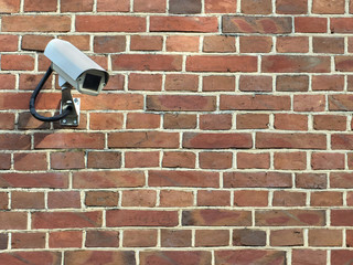 Video surveillance system installed on a brick wall.