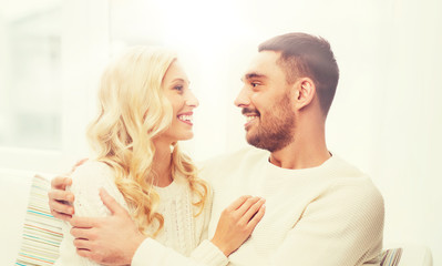 happy couple hugging on sofa at home