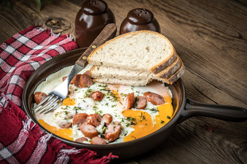 Tasty cooked egg with chopped sausages.