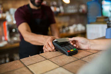 hands with payment terminal and credit card