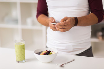 Obraz na płótnie Canvas man with smartphone having breakfast at home