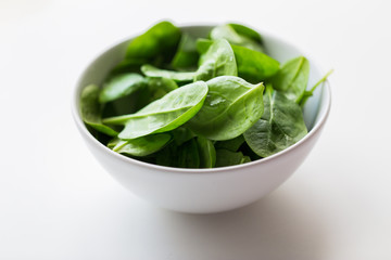 close up of spinach leaves in white bowl